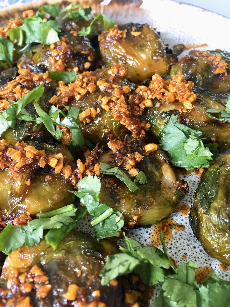 Gentle fried golden garlic on top of smashed Brussels sprouts.