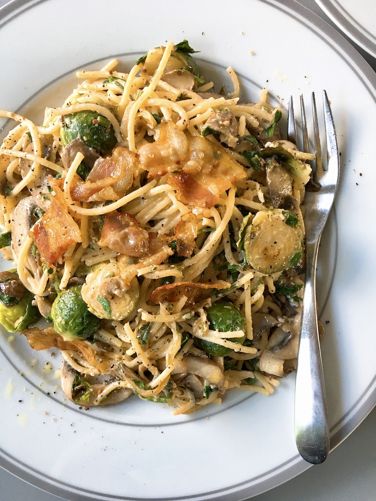 Cream sauce pasta with crispy bacon and Brussels sprouts.