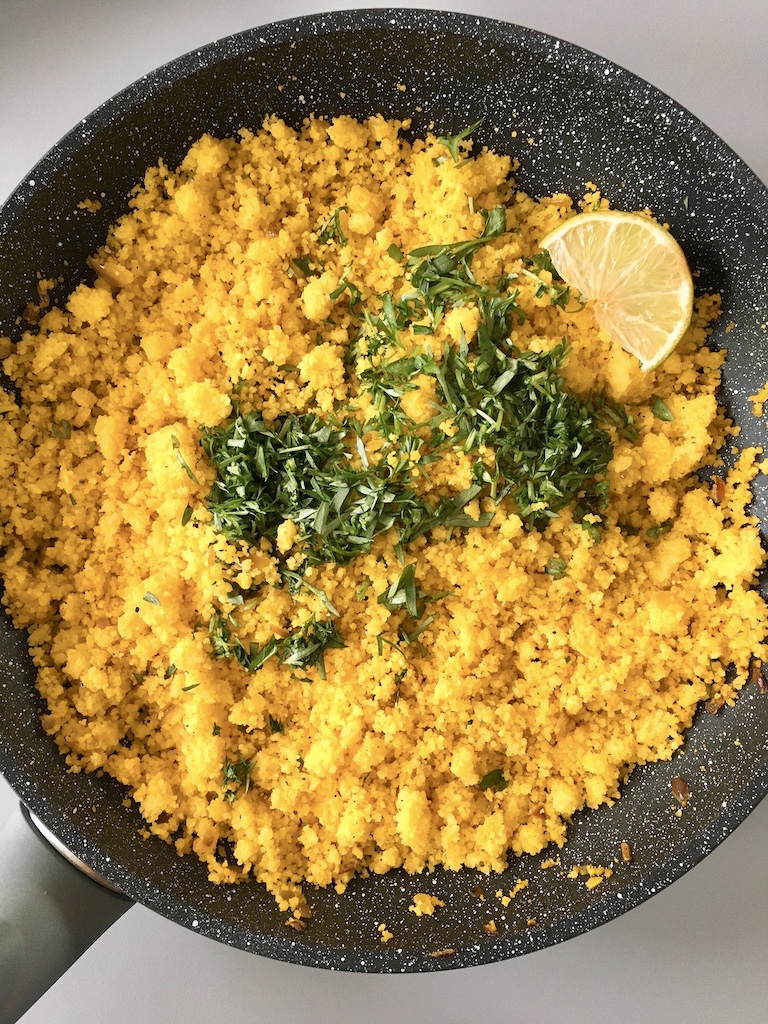 A pan of turmeric-yellow couscous.