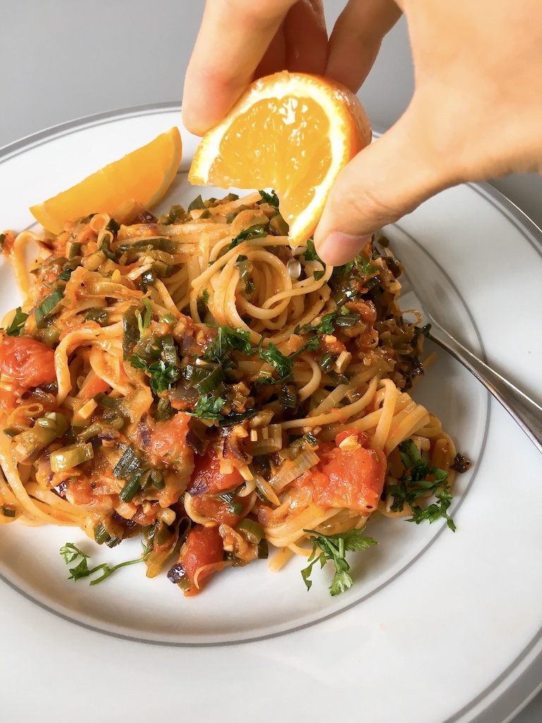 Squeezing orange juice over the salsa linguine.