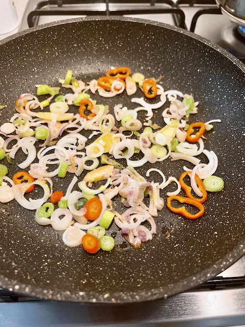 Sautéing ginger, chilli and shallots.