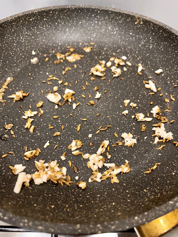 Fry cumin and garlic until fragrant.