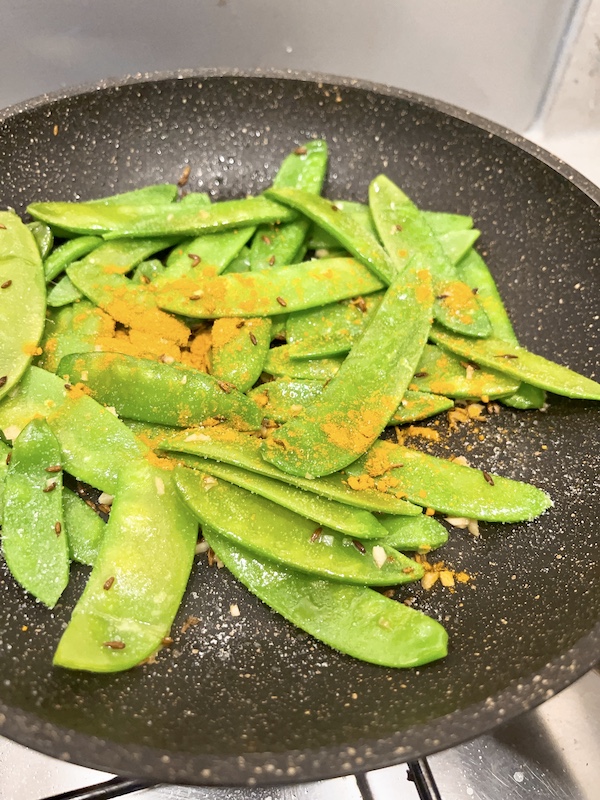 Season mangetout with salt and turmeric.