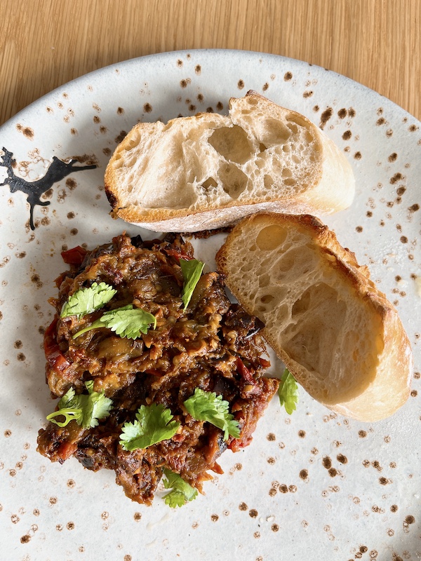 Moroccan zaalouk spread with sliced baguette.