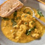 Fruity almond curry sauce with seafood, paired with baguette.