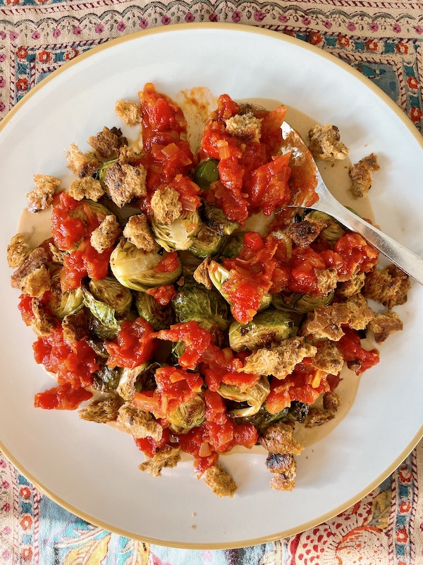 Roast Brussels sprouts with spicy tomato sauce and croutons.