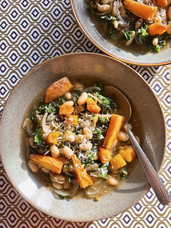 A vegan bean stew recipe made with roast squash and kale.