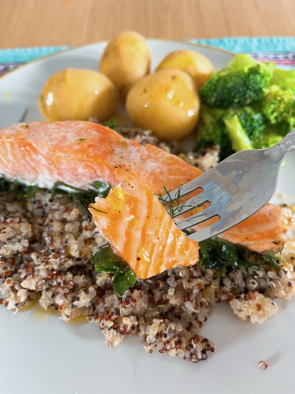 A piece of slow roast salmon with lemon vinaigrette, quinoa and boiled vegetables.