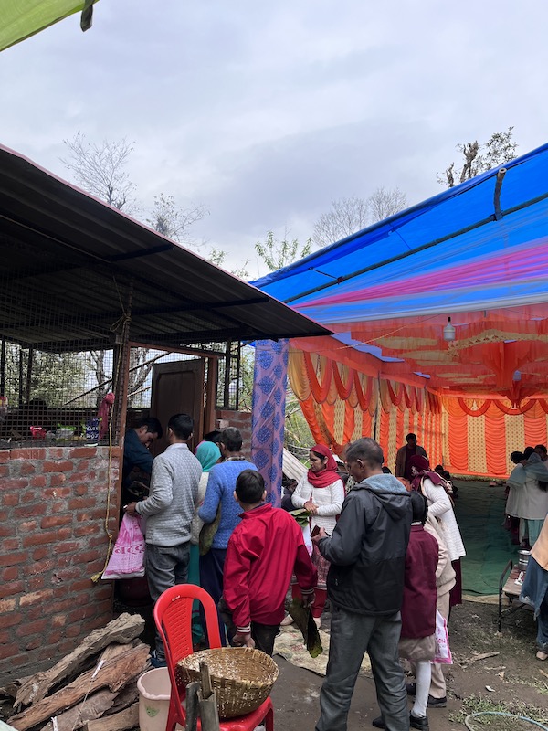 Locals take food from an Indian wedding.