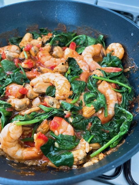 Making of one pot meal – spiced seafood over crispy orzo.