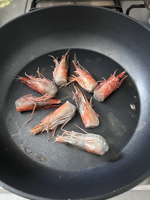 Pan-roasting prawn heads.