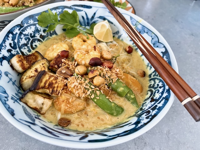 Twisted laksa soup with prawns, sugar snap peas, carrots and fried aubergine.