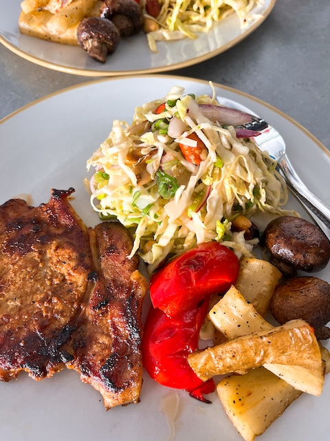 Asian slaw with roasted pork and vegetables.